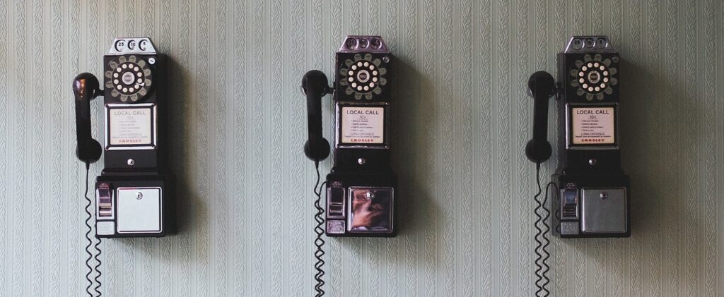 3 rotary dial phones mounted on the wall