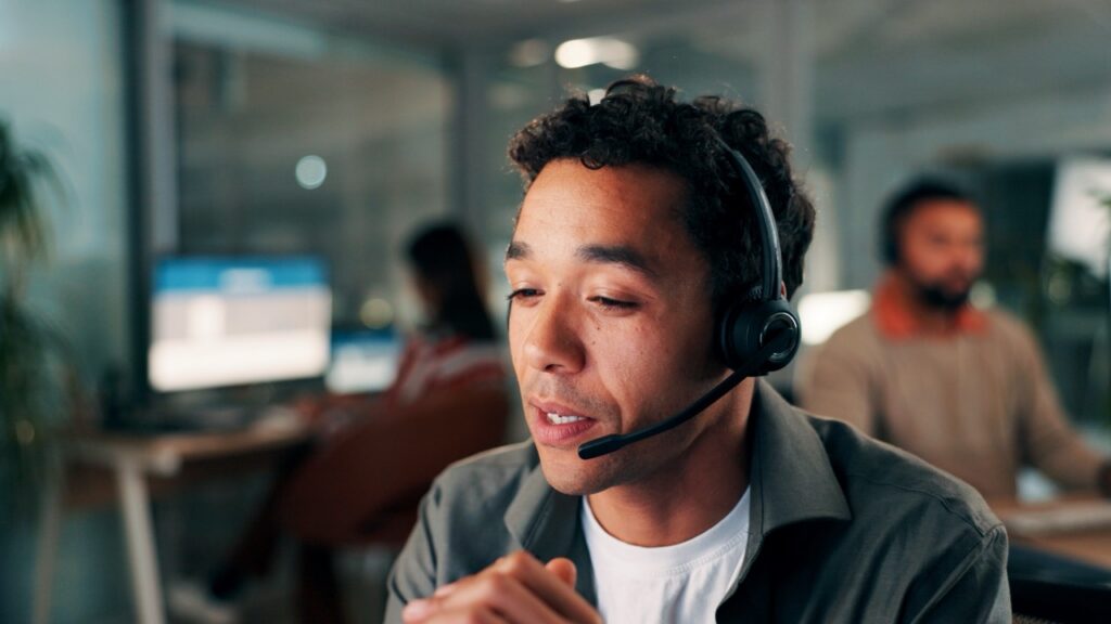 contact center agent reviewing a conversation analytics dashboard with sentiment and topic detection