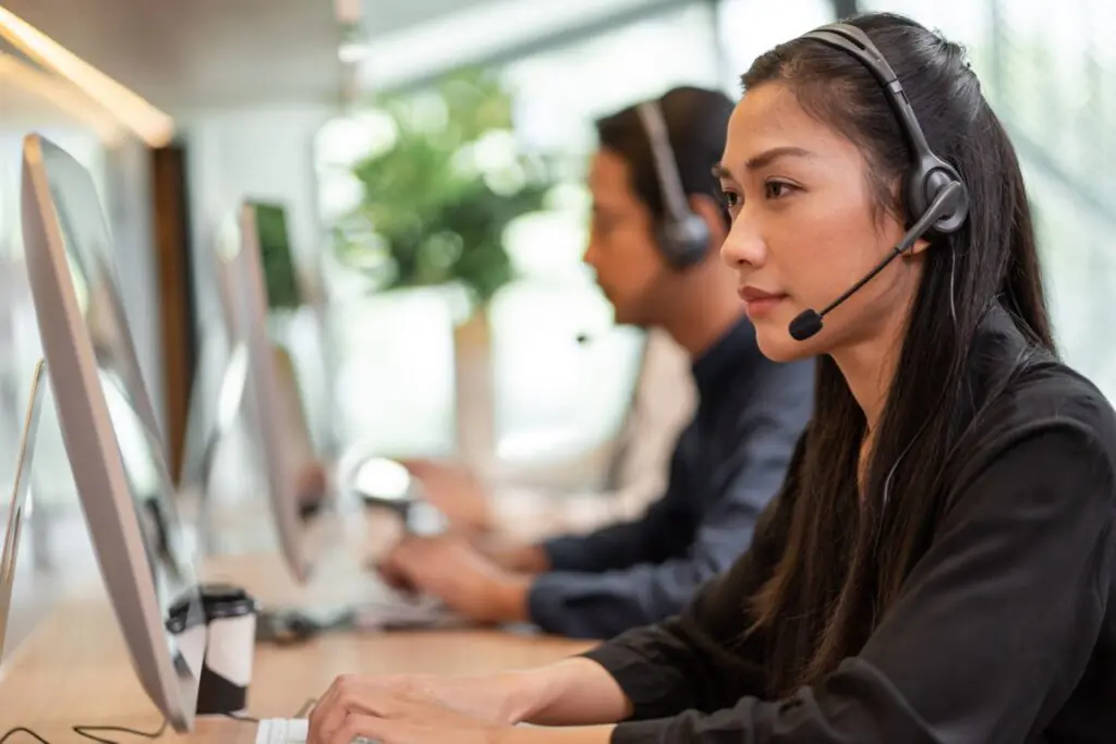 Contact center manager reviewing an automated QA scorecard dashboard built to scale with call volume