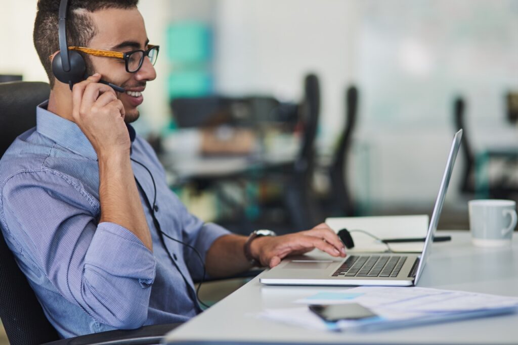 Agent on a headset working from a laptop in a small business contact center