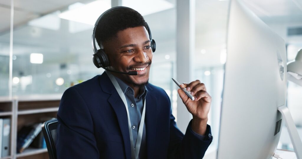 Smiling contact center agent with a headset on a customer call, supporting a contact center retention strategy