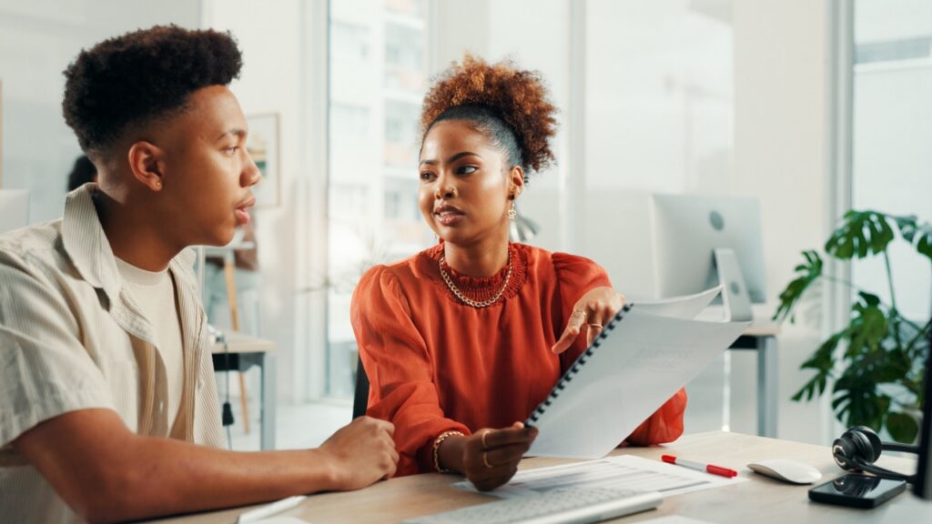 Contact center supervisor reviewing a QA scorecard report with an agent to address customer complaints
