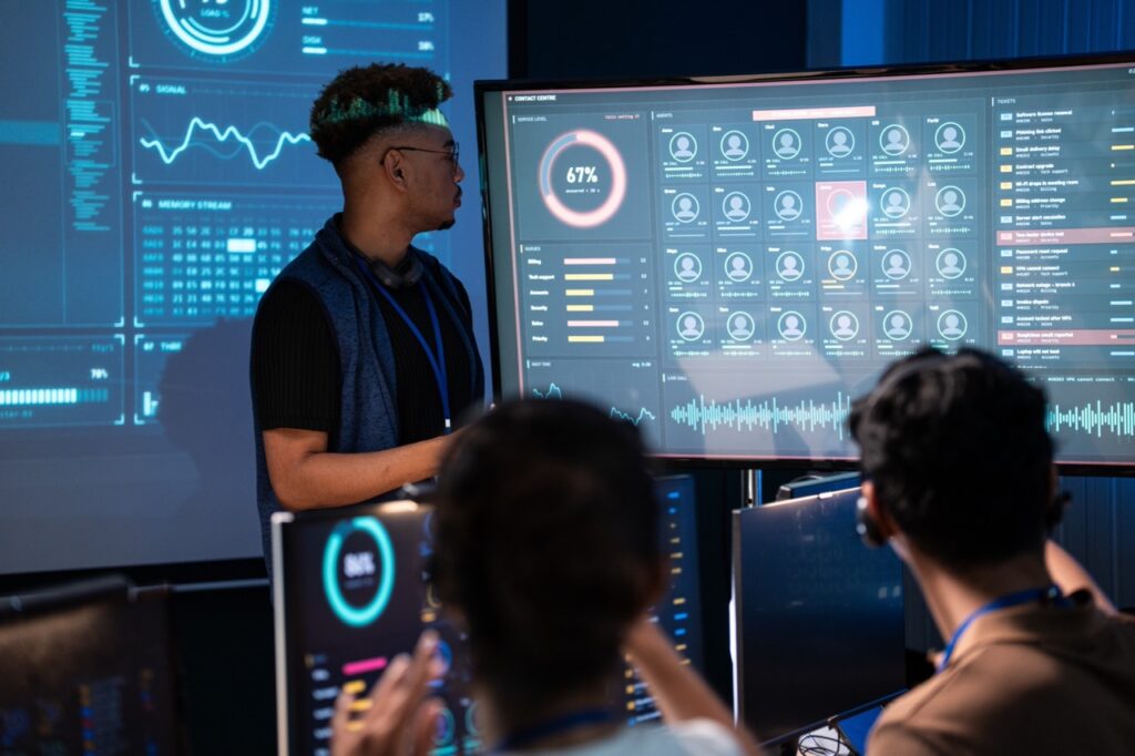 Contact center leader reviewing interaction analytics dashboards with agents
